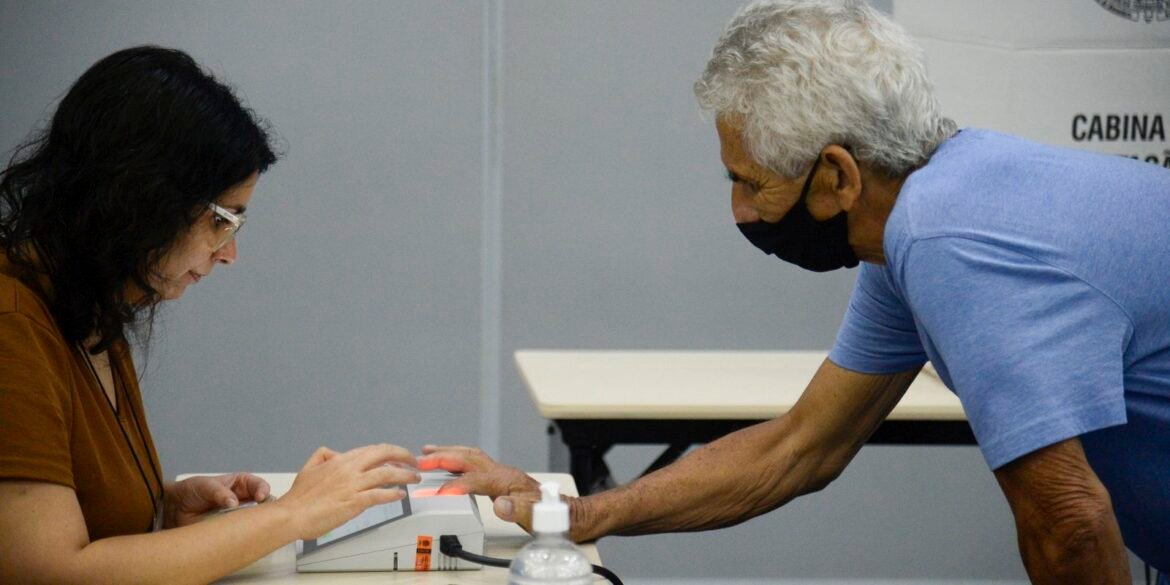 Eleitor e mesária em seção de votação no Rio de Janeiro.