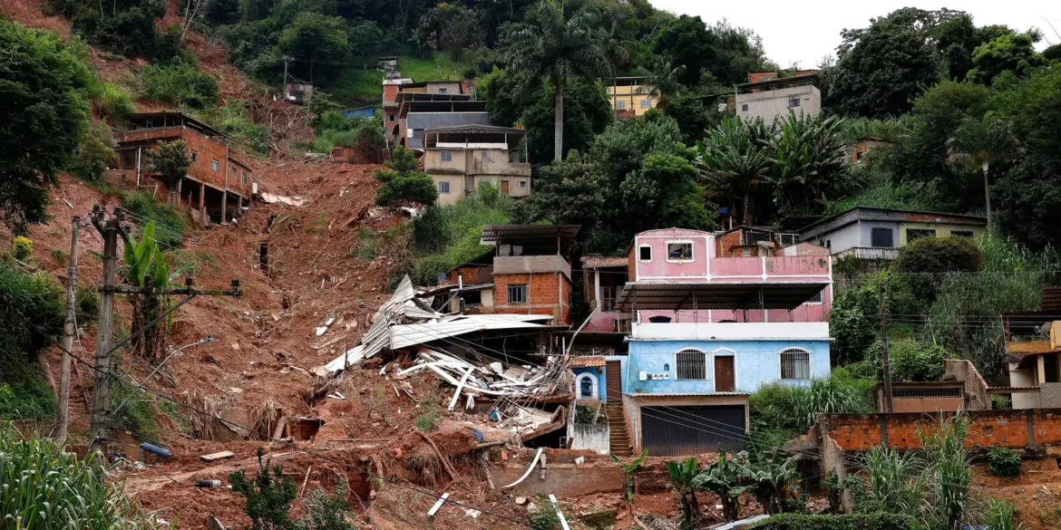 Casas em encosta com terra exposta e destroços.