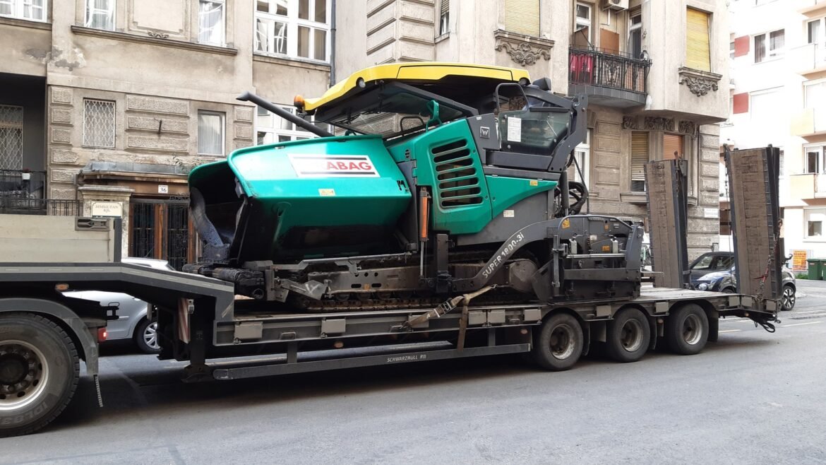 Pavimentadora transportada em carreta em Budapeste, Hungria. Foto de arquivo ilustrativa; não retrata as obras goianas.