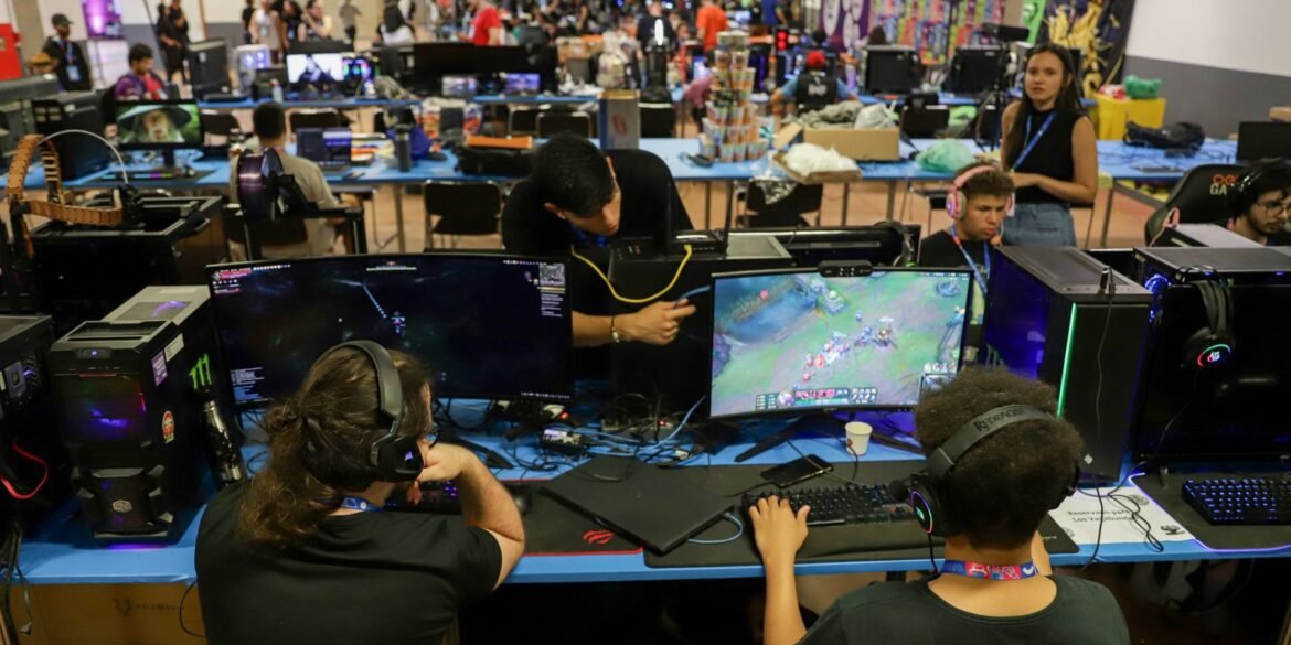 Participantes com fones de ouvido utilizam computadores para jogos eletrônicos