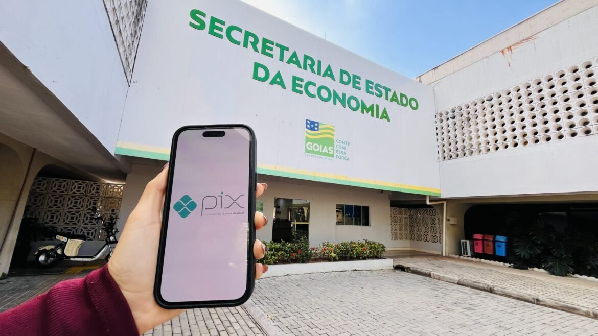 Celular com símbolo Pix em Goiás diante da Secretaria da Economia